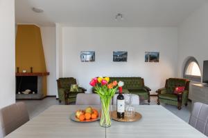 a dining room with a table with a vase of flowers at La Casetta in Tremezzo