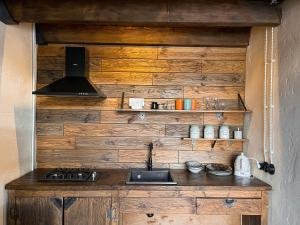 a kitchen with a wooden wall with a stove at Elia Loft in Stepantsminda