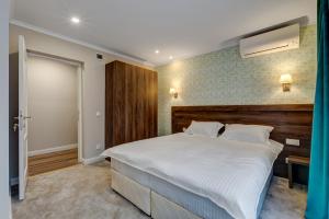 a bedroom with a large bed with a wooden headboard at Upstairs Boutique in Bucharest