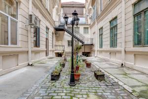 an empty alley with potted plants and a street light at Upstairs Boutique in Bucharest