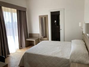 una camera con un letto bianco e una finestra di Hotel Nova Domus Aurelia a Roma
