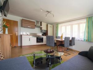 ein Wohnzimmer mit einem Tisch und einer Küche in der Unterkunft Appartement Bergmeister in Rauris
