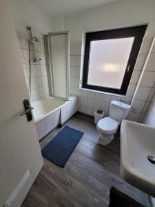 uma casa de banho com um WC, uma banheira e um lavatório. em City Apartment KL em Kaiserslautern