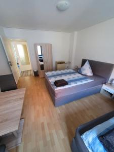 a bedroom with a large bed and a wooden floor at City Apartment KL in Kaiserslautern