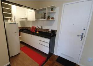 a kitchen with a white refrigerator and a red rug at Local Ideal - Lindo apartamento em Teresópolis in Teresópolis