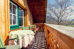 eine Veranda mit Stühlen, einem Tisch und einem Fenster in der Unterkunft Stangl - Hof in Bad Aussee