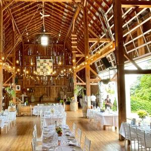 een eetkamer met witte tafels en stoelen in een gebouw bij The Eddie Hotel and Farm in Bloomfield
