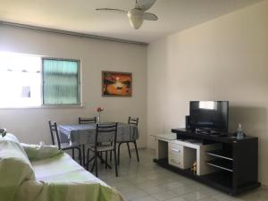 a bedroom with a bed and a table with a television at Mar Azul Condomínio in Aracaju
