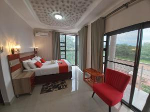 Top Stay Inn في كاسان: غرفة بالفندق سرير وكرسي احمر