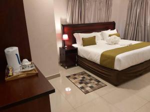um quarto de hotel com uma cama e uma mesa em Top Stay Inn em Kasane