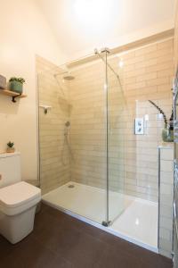 a bathroom with a shower and a toilet at Coach House Ratho Park Steading in Ratho