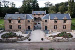 een groot bakstenen huis met twee grote binnenplaatsen bij Coach House Ratho Park Steading in Ratho