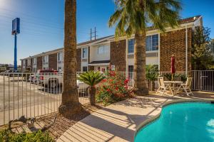 un edificio de apartamentos con piscina y palmeras en Motel 6 Tucson, AZ - North, en Tucson