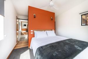 a bedroom with a large bed with an orange headboard at Little Oyster Bayview in Kettering