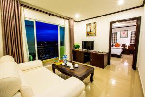 Una sala de estar con un sofá blanco y una ventana grande. en Douangchan Plaza Hotel, en Vientiane