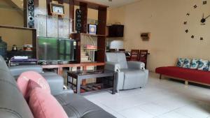 ein Wohnzimmer mit Sofas und einem Flachbild-TV in der Unterkunft Villa Batu Iggy in Batu