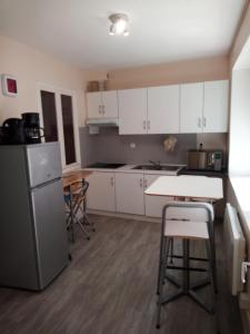 une cuisine avec des armoires blanches et une table et des chaises dans l'établissement EK Studio Appartement, à Saint Etienne