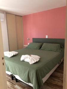 1 dormitorio con 1 cama con 2 toallas en Los Naranjos Apart Hotel en Villa Carlos Paz