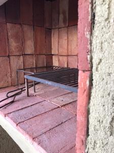 a metal bed sitting in a corner of a brick wall at Los Naranjos Apart Hotel in Villa Carlos Paz +41 photos