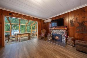 uma sala de estar com uma lareira, uma mesa e uma televisão em Koi Story Cabin on the Lake - Waterfront, near Bike Trail em Maple Valley