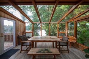 a screened in porch with a table and chairs at Koi Story Cabin on the Lake - Waterfront, near Bike Trail in Maple Valley