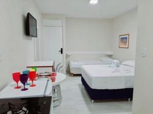 een hotelkamer met 2 bedden en drankjes op een tafel bij Apartamento à beira mar da praia do francês in Praia do Frances