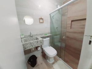 uma casa de banho com um WC e uma cabina de duche em vidro. em Apartamento à beira mar da praia do francês na Praia do Francês