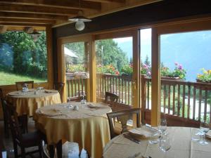 a dining room with two tables and a balcony at Les Combes in La Salle