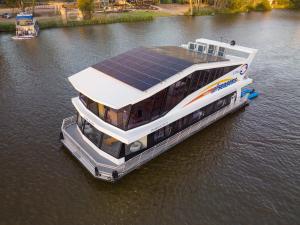 a boat with solar panels on the water at All Seasons Houseboats in Mildura