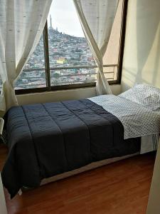 een bed in een kamer met een groot raam bij Departamento Sector Central Coquimbo, Vista al Puerto in Coquimbo