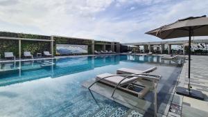 馬尼拉的住宿－Hotel Okura Manila - Staycation Approved，一个带椅子和遮阳伞的游泳池