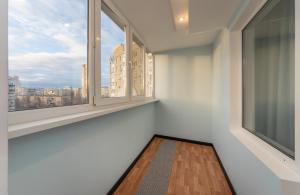 an empty room with two windows and a wooden floor at Modern 3 bedroom apartment in Kyiv