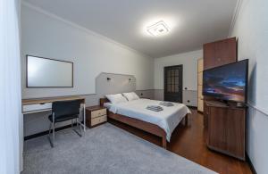 a bedroom with a bed and a desk and a flat screen tv at Modern 3 bedroom apartment in Kyiv