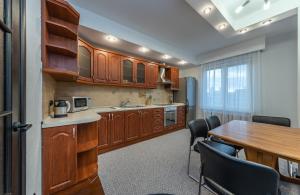 a kitchen with wooden cabinets and a table with chairs at Modern 3 bedroom apartment in Kyiv