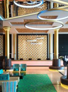 a lobby of a hotel with chairs and a green rug at Thon Hotel Opera in Oslo