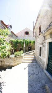 - un bâtiment en pierre avec une porte et des escaliers à côté dans l'établissement Holiday home Villa Vanya, à Mali Ston