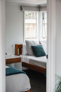 a bedroom with two beds and a window at Te Puna Cottage Gardens B&B in Tauranga