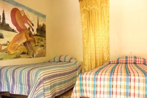 Habitación con 2 camas y una pintura en la pared. en Hotel Bruno's Place, en El Remate