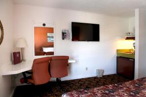 a hotel room with a desk and a television at Granada Inn in Santa Clara