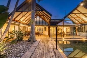 a house with a wooden deck and a swimming pool at Coorabell Estate in Coorabell Creek