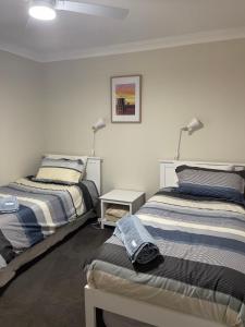 a room with two beds and a table with lamps at Kulin Erindale Apartments in Kulin