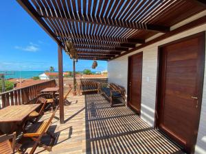 a wooden deck with tables and benches on a building at Flat Por do Sol in Baía Formosa
