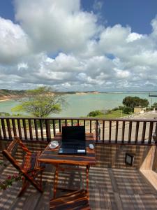 a laptop computer sitting on a table on a balcony at Flat Por do Sol in Baía Formosa +11 photos
