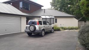 uma SUV prateada estacionada em frente a uma casa em Quiet location ,central to city em Hamilton