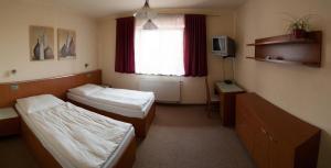 Cette chambre comprend 2 lits et une fenêtre. dans l'établissement Hotel Ostrov Garni, à Sadská