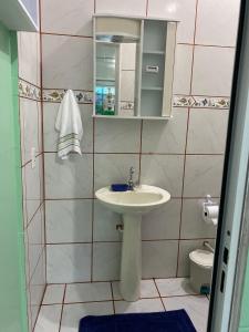 een kleine badkamer met een wastafel en een toilet bij Kitnet Praia do Trapiche in Penha
