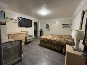 a hotel room with a bed and a flat screen tv at Flamingo Motel Oxnard in Oxnard
