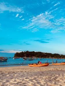 um grupo de pessoas em barcos em uma praia em Kitnet Praia do Trapiche em Penha