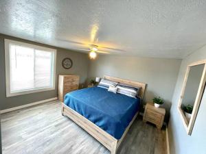 una camera da letto con un letto con lenzuola blu e una finestra di The Willow Tree. Modern comfort for families. 