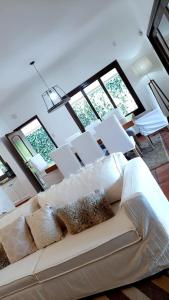 a living room with a white couch and windows at Casa del buen recuerdo San Lorenzo -SALTA- in San Lorenzo
